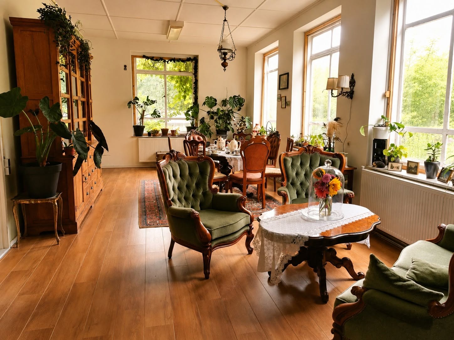 Het gezellige theehuis van de GroeiFabryk met groene fauteuils, houten tafels en veel planten